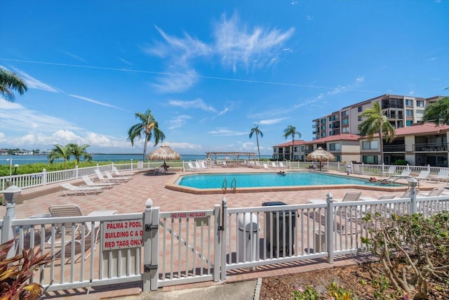 view of swimming pool with a water view and a patio area