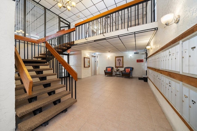 stairs featuring a high ceiling and a mail area