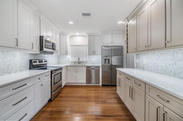 kitchen featuring dark hardwood / wood-style floors, sink, appliances with stainless steel finishes, and decorative backsplash