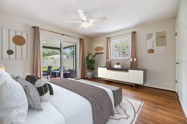 bedroom with hardwood / wood-style floors, ceiling fan, access to outside, and a textured ceiling