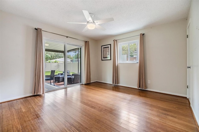 unfurnished room featuring ceiling fan, wood-type flooring, and a textured ceiling