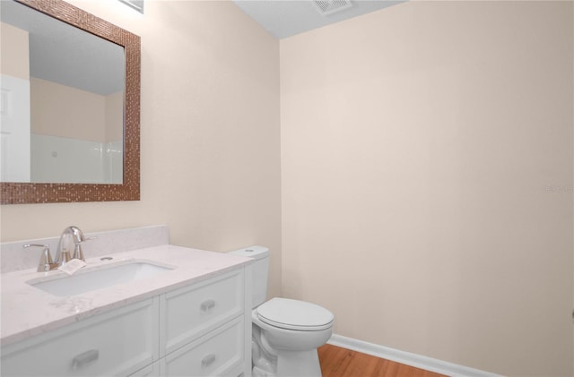 bathroom with wood-type flooring, toilet, and vanity