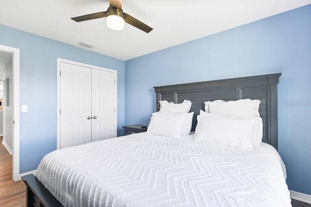 bedroom featuring hardwood / wood-style floors, ceiling fan, and a closet