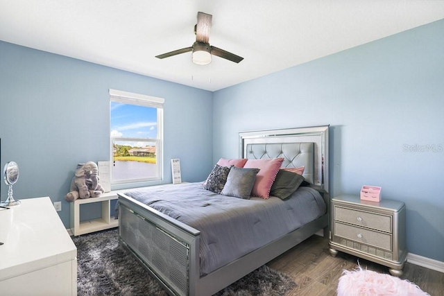 bedroom with dark hardwood / wood-style floors and ceiling fan