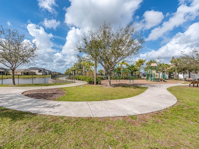 view of property's community featuring a playground, a yard, and a water view