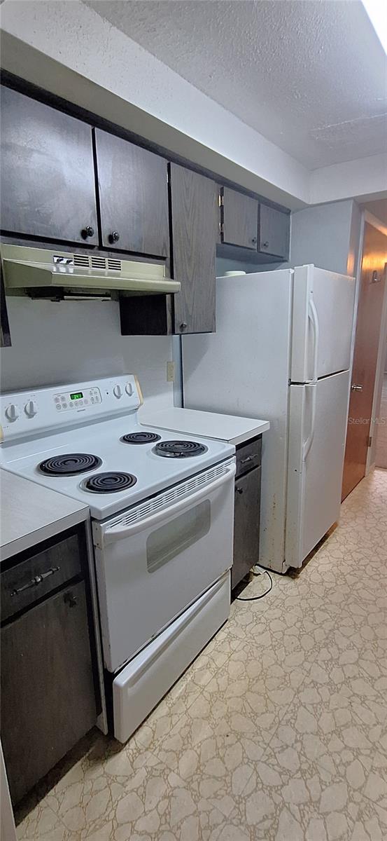 kitchen featuring white appliances and a textured ceiling