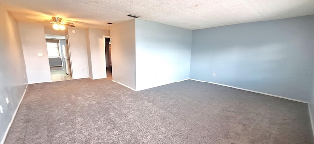 carpeted empty room with ceiling fan and a textured ceiling