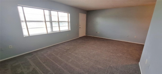 carpeted empty room featuring a textured ceiling