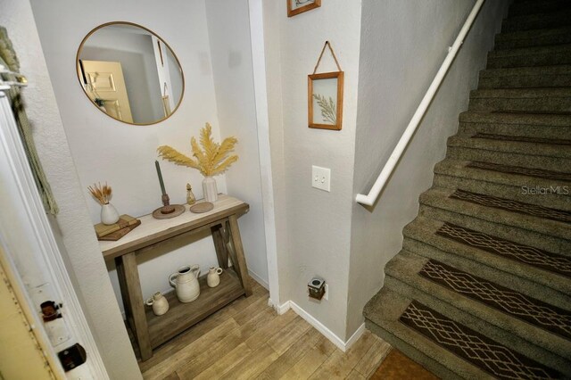 stairs featuring hardwood / wood-style floors