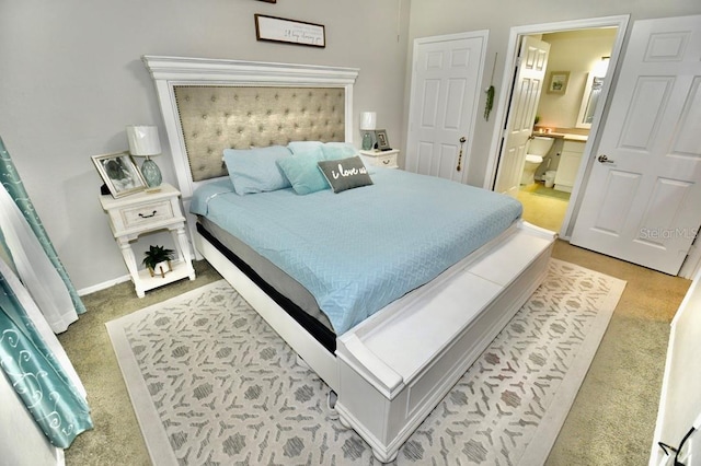 bedroom with light colored carpet and ensuite bath