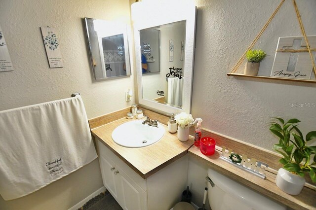 bathroom featuring vanity and toilet