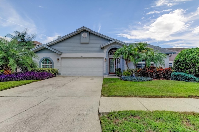 ranch-style home featuring an attached garage, driveway, and a front yard
