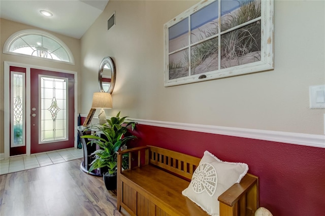 foyer entrance with vaulted ceiling and hardwood / wood-style flooring