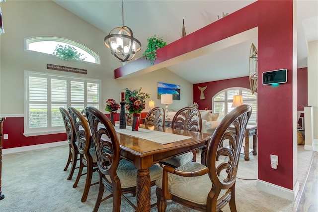 dining room featuring a chandelier, light colored carpet, and baseboards