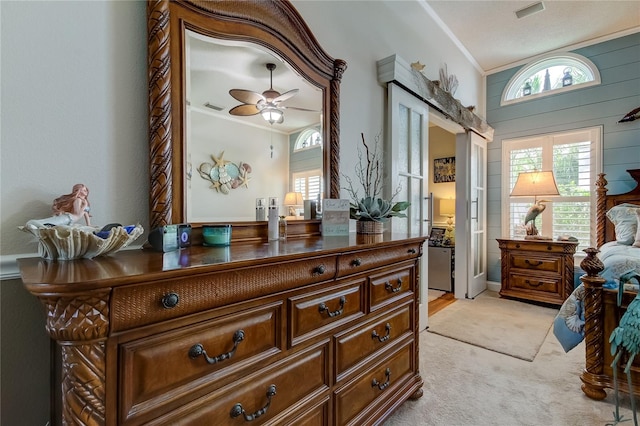 bedroom featuring crown molding, light carpet, wooden walls, and multiple windows