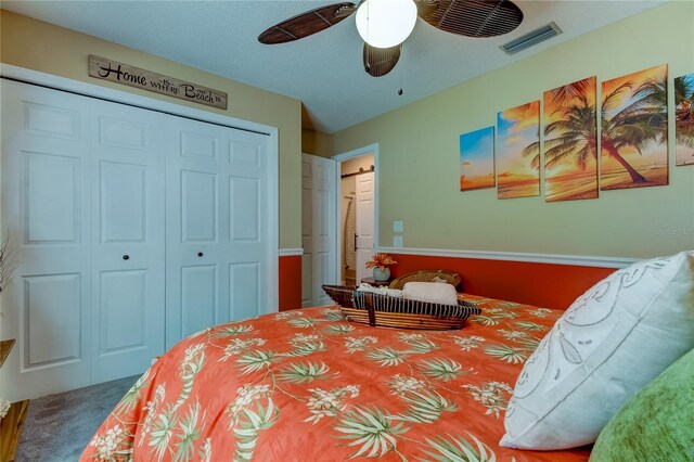 carpeted bedroom featuring a closet, visible vents, and a ceiling fan