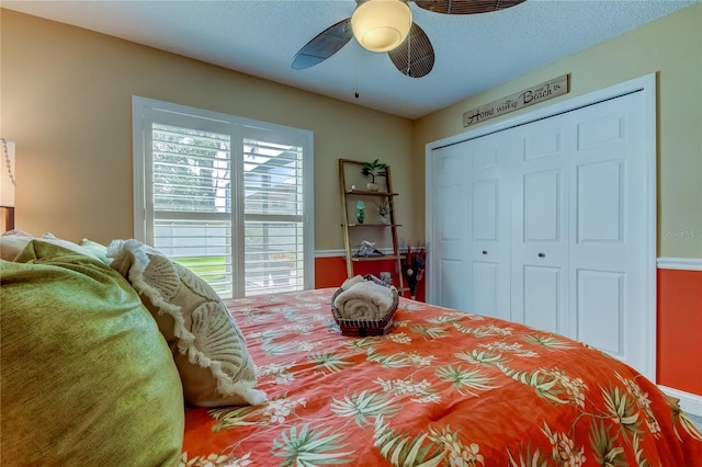 bedroom with a closet, a textured ceiling, and ceiling fan