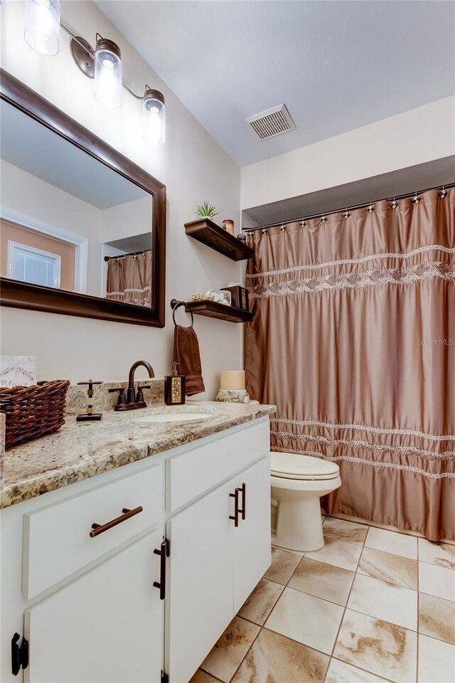full bath with visible vents, curtained shower, toilet, and vanity
