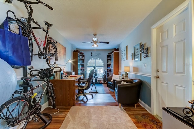 home office featuring wood finished floors and ceiling fan