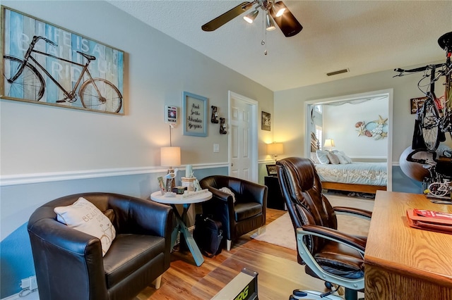 office area featuring visible vents, a textured ceiling, ceiling fan, and wood finished floors