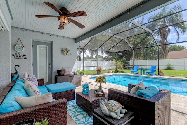 exterior space featuring an outdoor living space, ceiling fan, glass enclosure, and a patio