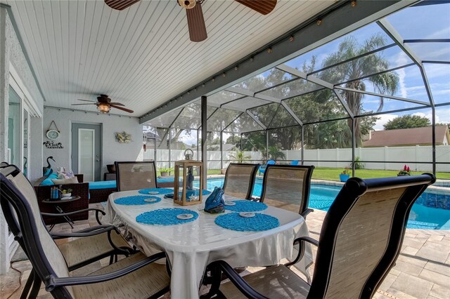 view of patio featuring glass enclosure, a fenced in pool, and ceiling fan