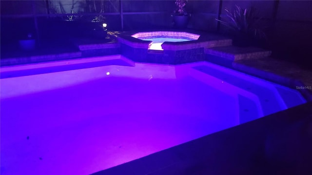 view of swimming pool with an in ground hot tub