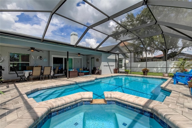 view of pool with a patio, a ceiling fan, fence, a pool with connected hot tub, and an outdoor hangout area