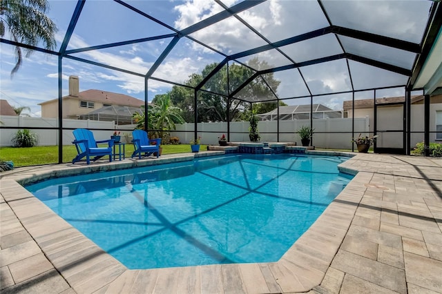 view of swimming pool with glass enclosure, a patio, a fenced backyard, and a pool with connected hot tub