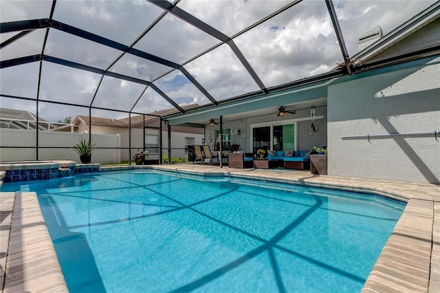 outdoor pool featuring an outdoor living space, ceiling fan, glass enclosure, a patio area, and an in ground hot tub