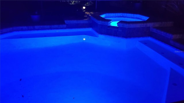 outdoor pool featuring an in ground hot tub