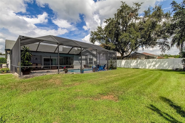 rear view of house with a fenced in pool, fence, a lawn, glass enclosure, and a patio area