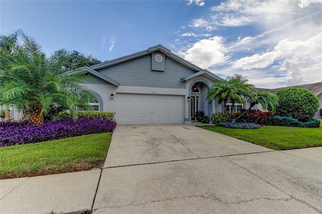 view of front of home featuring a garage, concrete driveway, and a front yard