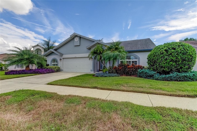 view of front of house with stucco siding, concrete driveway, a garage, and a front yard
