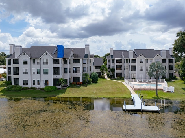 view of property with a water view and a community pool