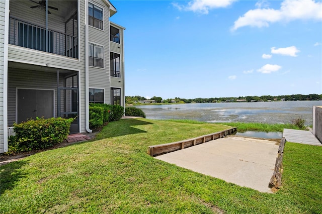 view of yard featuring a water view, a patio area, and a balcony