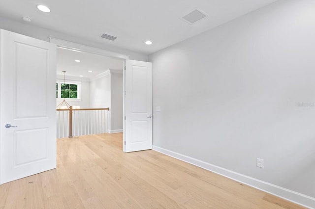 empty room with light wood-type flooring and ornamental molding