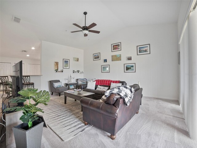 carpeted living room featuring vaulted ceiling and ceiling fan