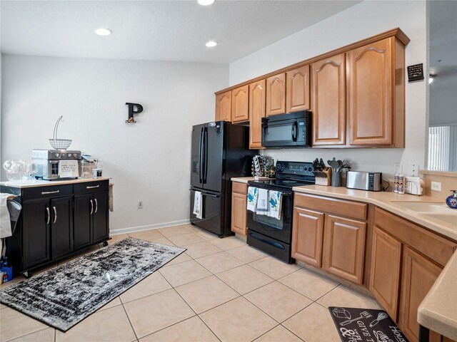 kitchen featuring black appliances, vaulted ceiling, sink, and light tile patterned floors