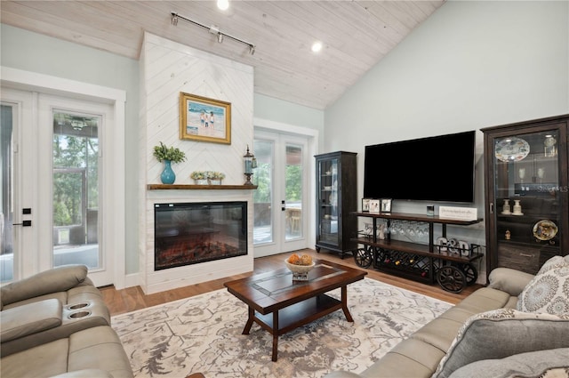 living room with a wealth of natural light, a large fireplace, high vaulted ceiling, and wooden ceiling