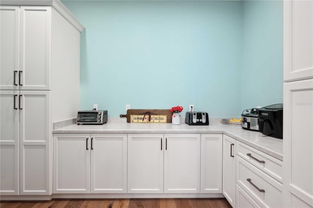 kitchen featuring white cabinets and hardwood / wood-style flooring