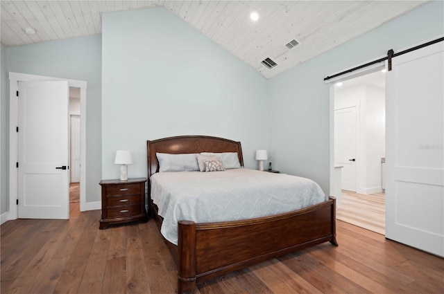 bedroom with a barn door, hardwood / wood-style floors, and wood ceiling