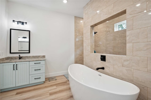 bathroom featuring vanity, a bath, and hardwood / wood-style flooring