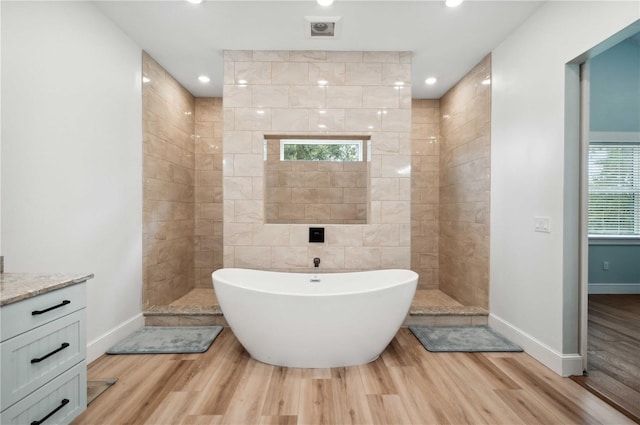 bathroom featuring hardwood / wood-style flooring, vanity, and shower with separate bathtub