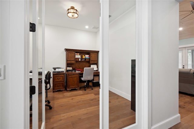 office space featuring built in desk and light wood-type flooring