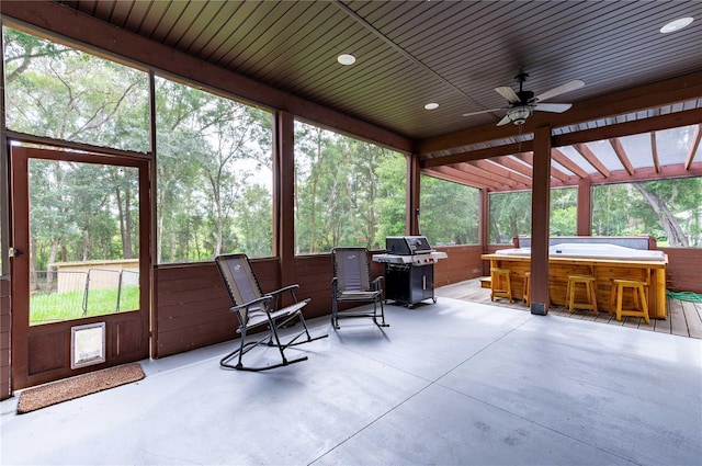 sunroom / solarium with a hot tub and ceiling fan