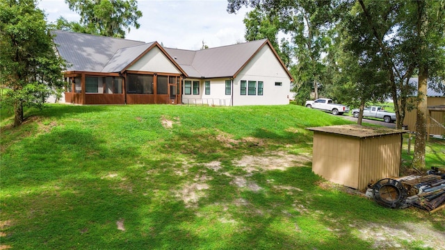 back of house with a lawn and a sunroom