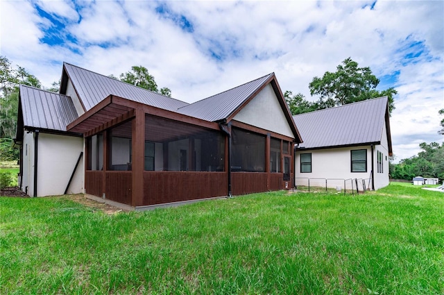 back of house with a sunroom and a yard