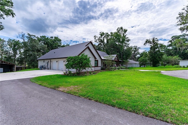 view of side of property featuring a lawn and a garage