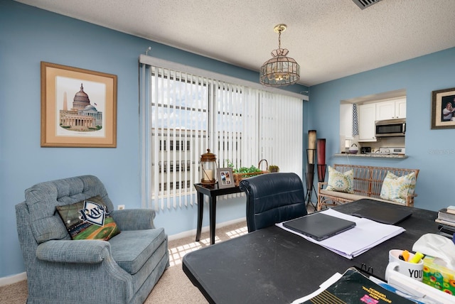 carpeted office with an inviting chandelier and a textured ceiling